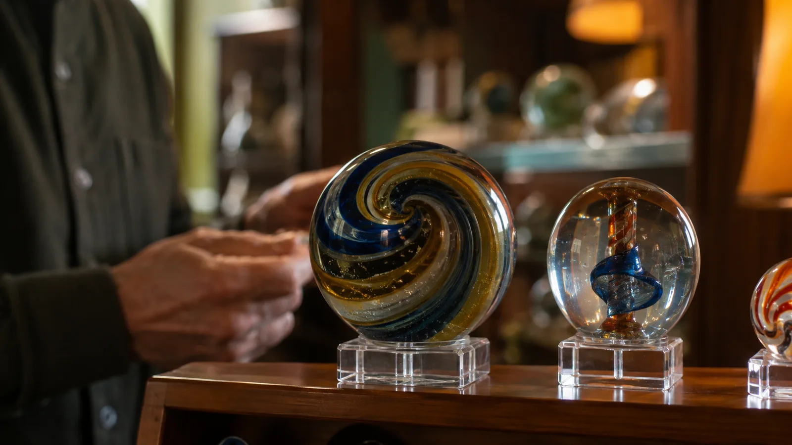 A deep swirl and pontil marble standing on an acrylic easel as a collector examines it at eye level